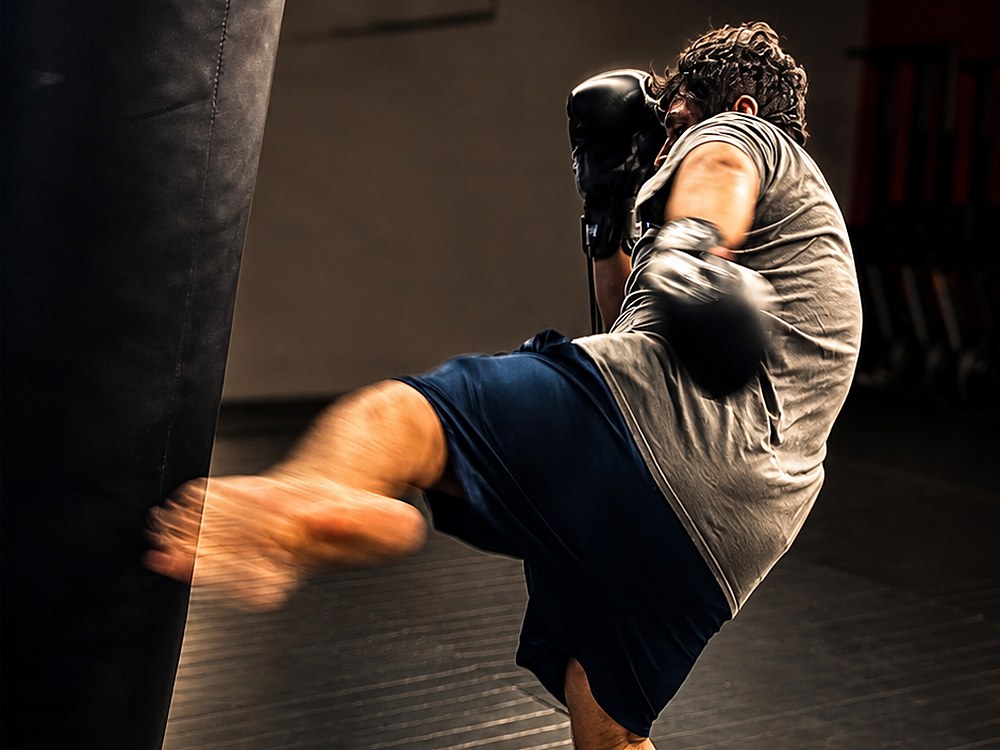 A student throwing a kick on the heavy bag at Laguna Muay Thai