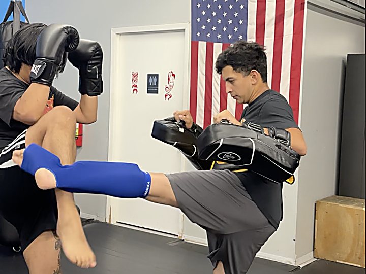 Teen throwing a high kick at Laguna Muay Thai